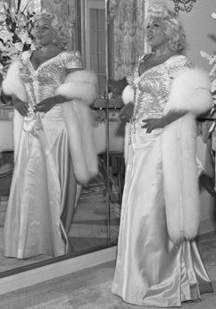 ماي ويست تتخذ وضعية تصويرية بفستان ساحر وابتسامة واثقة، 1953.