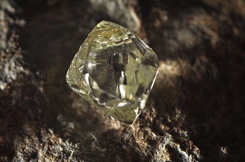 يبرز حجر ثماني الأوجه شفاف من صخرة سوداء