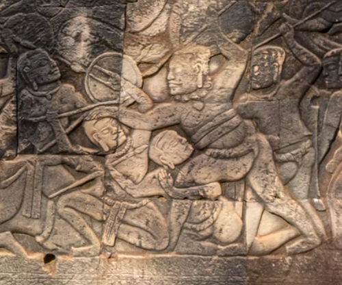 أسلوب القتال الأرضي: مسك الساق والهجوم بالرمح من الأرض. نقش بارز في معبد بايون (القرن الثاني عشر/الثالث عشر الميلادي).