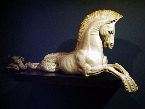 النحت الأبيض من مخلوق mi-cheval mi-poisson présentée de Profile، sa queue enroulée à l'arrière et ses antérieurs étant palmés.