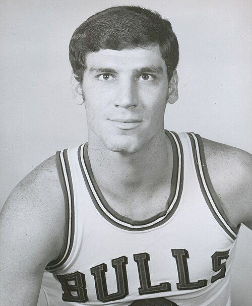 صورة بالأبيض والأسود لرجل أبيض يرتدي زيًا أبيض مكتوب عليه "Bulls".