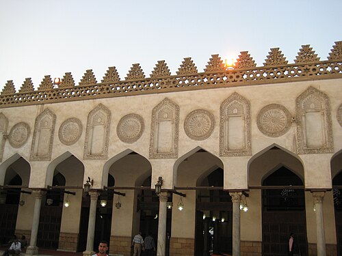 تظهر خمسة أقواس على شكل عارضة (وجزء من قوس سادس). ترتكز هذه الأقواس على أعمدة أسطوانية. يعلو كل قوس زخرفة جصية دائرية كبيرة محفورة، ويعلو كل عمود زخرفة جصية كبيرة محفورة تعكس شكل القوس والأعمدة. خلف صف الأعمدة ممر، ثم جدار بمداخل على شكل وحجم الأقواس والأعمدة.