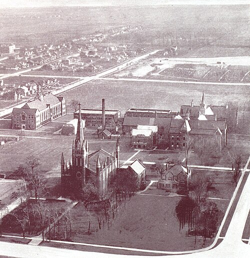 صورة جوية لحرم كلية أسومبشن في عام 1928. تظهر بعض المباني مع مساحات واسعة من الأراضي الفارغة.