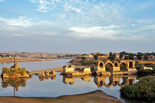بقايا جسر وسد، في بحيرة هادئة.