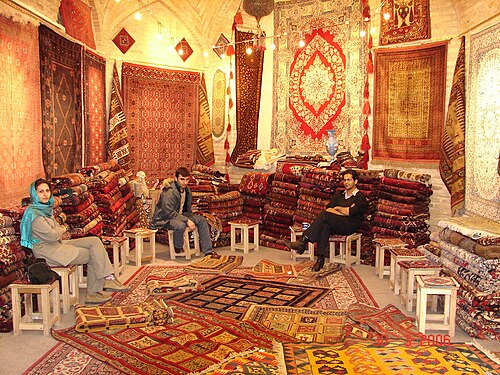 ثلاثة أشخاص يجلسون في متجر سجاد