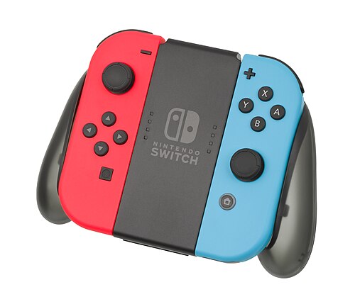 تم تركيب وحدتي التحكم Joy-Con باللونين الأحمر والأزرق على مقبض الشحن، مما أعطى الأبعاد العامة لوحدة تحكم قياسية.