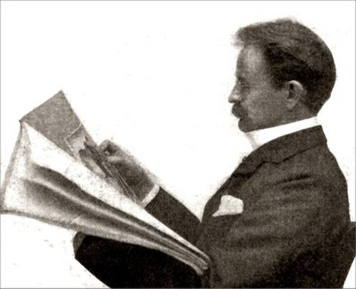 رجل من العصر الفيكتوري في منتصف العمر، ذو شارب، جالس يقرأ جريدة، يُرى من الجانب الأيسر
