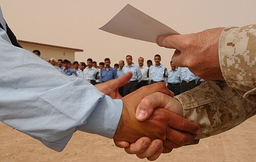 المصافحة باليد اليمنى أثناء تسليم الشهادة باليد اليسرى