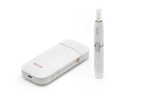 جهاز iQOS من شركة فيليب موريس إنترناشونال مع شاحن وعود تبغ.
