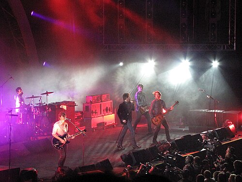 فرقة Powderfinger على المسرح، مع كوجيل على اليسار على الطبول، ثم ميدلتون على الجيتار، وفانينج في منتصف المسرح يغني في الميكروفون، وكولينز على جيتار البيس الخاص به، وهاوج في أقصى اليمين.