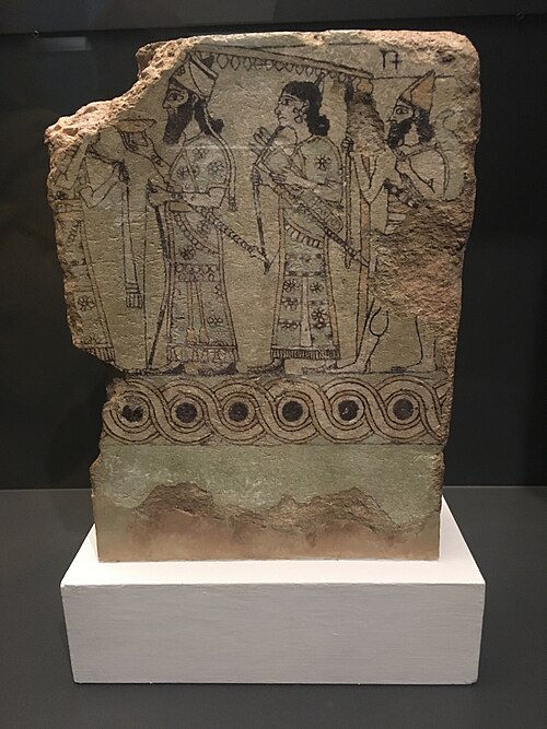بلاطة آشورية ذات حافة مزخرفة بنقوش غيوشيه، من القصر الشمالي الغربي في نمرود (الواقعة حاليًا في العراق)، 883-859 قبل الميلاد، من الخزف المزجج، المتحف البريطاني، لندن