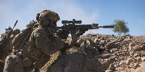 بندقية M27 مزودة بمنظار بصري مشترك للفرقة (SCO)، وكاتم صوت KAC NT4 QDSS، وجهاز AN/PEQ-16