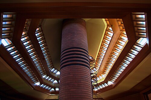 The living room's roof as seen from below. There are three bands of clerestory windows on the roof. In the center is a round chimney shaft