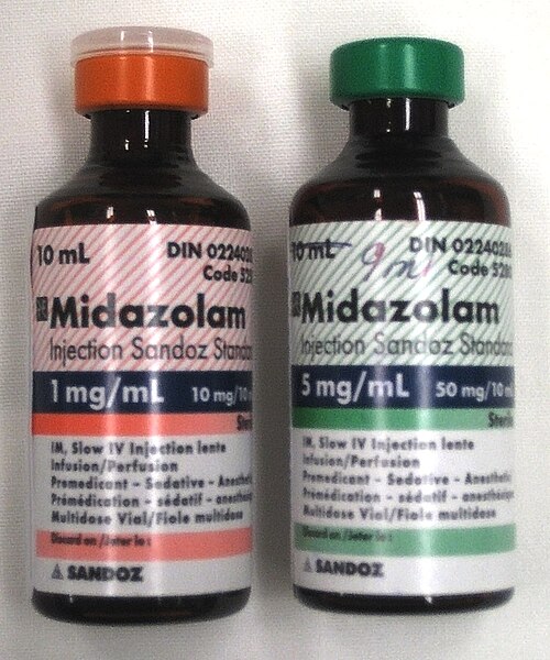 زجاجتان سعة كل منهما ١٠ مل تحملان اسم ميدازولام. الزجاجة على اليسار تحمل ملصقًا أحمر اللون مكتوب عليه ١ ملغ/مل، أما الزجاجة على اليمين فملصقها أخضر اللون ومكتوب عليه ٥ ملغ/مل. كلا الزجاجتين تحتويان على كتابة صغيرة جدًا.