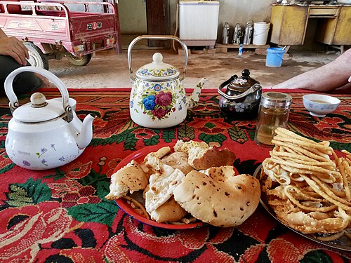 وجبات خفيفة وشاي على طاولة في فناء