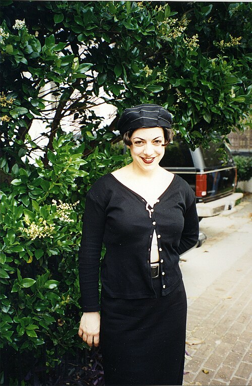 امرأة ترتدي تنورة طويلة سوداء وبلوزة وقبعة، 1995.