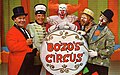 بطاقة بريدية تعود إلى عام 1968، الطاقم الرئيسي لسيرك بوزو (WGN-TV)؛ من اليسار إلى اليمين، مدير الحلبة نيد (نيد لوك)، السيد بوب (قائد الفرقة بوب تريندلر)، بوزو المهرج (بوب بيل)، أوليفر أو. أوليفر (راي راينر)، ساندي المهرج (دون ساندبرج)