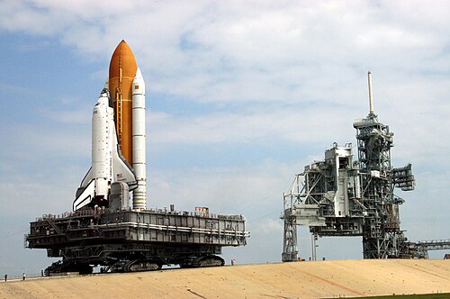 تتحرك ناقلة مجنزرة تحمل مكوك ديسكفري (STS-114) على المنحدر المؤدي إلى منصة الإطلاق 39B. ويمكن رفع الجزء الخلفي من المركبة، مما يحافظ على مستوى المكوك ومنصة الإطلاق.
