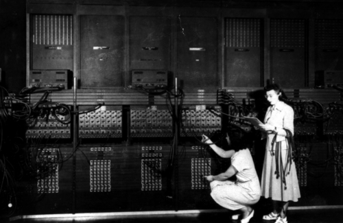 إستر جيرستون (واقفة) وجلوريا جوردون بولوتسكي تعيدان برمجة جهاز ENIAC في عام 1946.