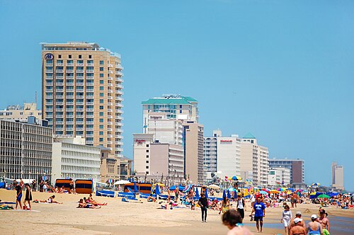 تصطف الفنادق الشاهقة على طول الواجهة البحرية المغطاة بالرواد الملونين على الشاطئ.