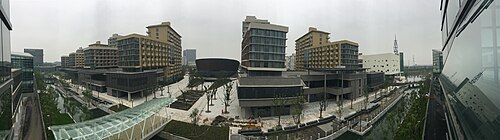 حرم جامعة شنغهاي للتكنولوجيا. ستة مساكن لطلاب الدراسات العليا، وقاعة الرياضة (في الوسط) والمكتبة (المبنى الأبيض على اليمين) (نوفمبر 2015).