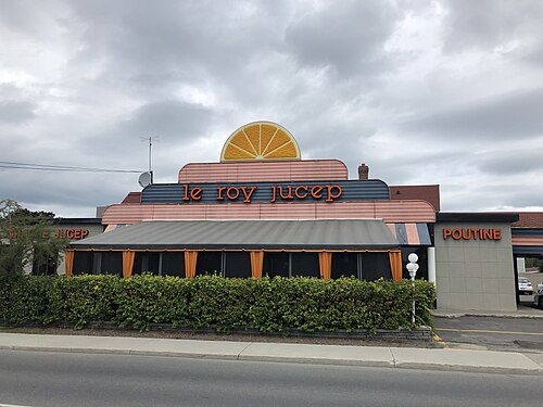مطعم عليه لافتات على الجدار الأمامي مكتوب عليها "le roy jucep" و "poutine"