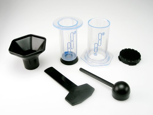 جهاز AeroPress الأصلي المصنوع من البلاستيك الشفاف مع ملحقاته. لا تخلط بينه وبين منتج AeroPress Clear الجديد.