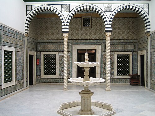 فناء القصر الصغير به نافورة رخامية في وسط الفناء وعمود.