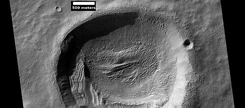 Layered feature in crater, as seen by HiRISE under the HiWish program These features were described by a group of scientists at a conference in Texas. https://www.hou.usra.edu/meetings/lpsc2025/pdf/1938.pdf Blanc. E., et al. 2025. DIPPING LAYERED DEPOSITS ON MARS: IMPLICATIONS FOR CLIMATE-DRIVEN MIDLATITUDE PROCESSES.