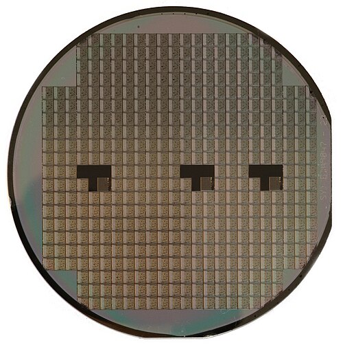 رقاقة سيليكون؛ الأجهزة الفردية (VLSI في مربعات) غير قابلة للاستخدام حتى يتم تقطيعها وتوصيلها بالأسلاك وتغليفها.