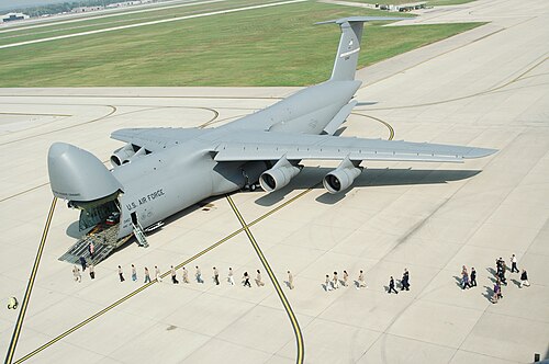 اصطف الزوار تحت مقدمة طائرة النقل العسكرية C-5A Galaxy المرفوعة في فعالية تعريفية عامة، مما يوضح حجم الطائرة.