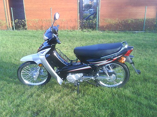 دراجة Kymco Activ ذات الهيكل السفلي. تتميز هذه الدراجة بأنبوب سفلي مائل، وهو ما يُعرف بالهيكل السفلي، كما أنها لا تحتوي على منصة للقدم، وهو ما يُعرف بالسكوتر.