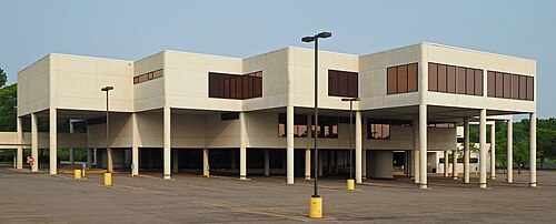 مكتبة ساوثديل، مبنى أبيض حديث الطراز ذو تصميم متدرج معكوس مدعوم بأعمدة فوق موقف السيارات الخاص بها في يوم مشمس