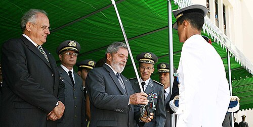President Lula da Silva and the Minister of Defence Nelson Jobim delivering a sword during a graduation.
