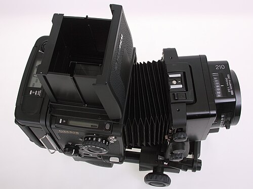 هيكل كاميرا Fuji GX680III الاحترافي مع منفاخ طويل، ومحدد منظر قابل للطي على مستوى الخصر، وحامل فيلم لفة IIIN (وضع أفقي) وعدسة EBC Fujinon GX 210mm 1:5.6 (إمالة لليسار، تحريك لليسار)