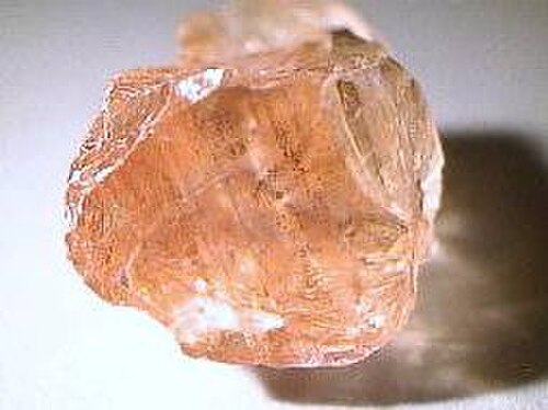 صخرة وردية متعددة الأسطح ينعكس عليها الضوء في نقاط مختلفة.