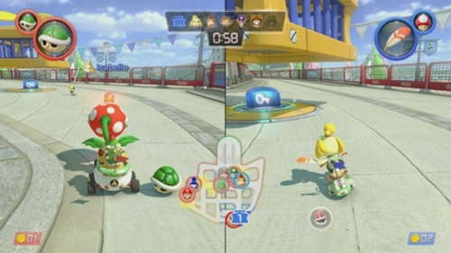 Two characters in split-screen view on a concrete surface. On the left is Bowser Jr., a yellow turtle-like creature with a spiked green shell who is riding in a small circular car. In front of him is a Piranha Plant, a venus flytrap-like creature with a white-spotted red head. On the right is Isabelle, a humanoid yellow dog on a motorbike. Isabelle is driving toward a blue switch with a key icon placed below a yellow and blue cage. In the center of the screen is a minimap displaying the characters' location in the course.